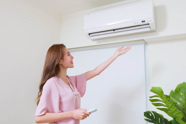A woman turns on the mini split air conditioner - How many mini splits do I need